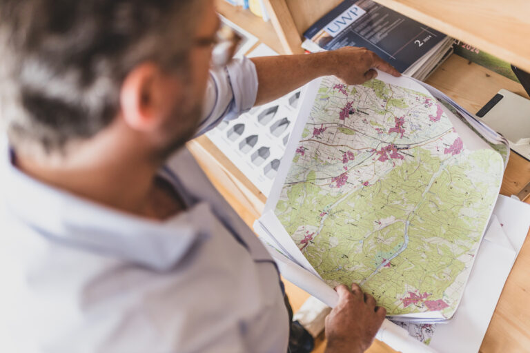 Thomas Büttner blickt auf eine Landkarte.